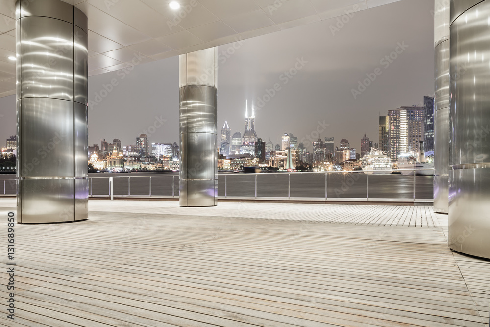 Empty floor with modern skyline and buildings at night in Shanghai