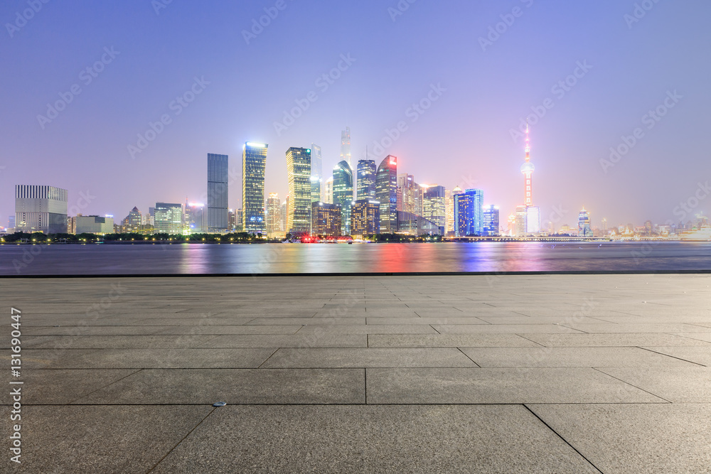 Empty floor with modern skyline and buildings at night in Shanghai