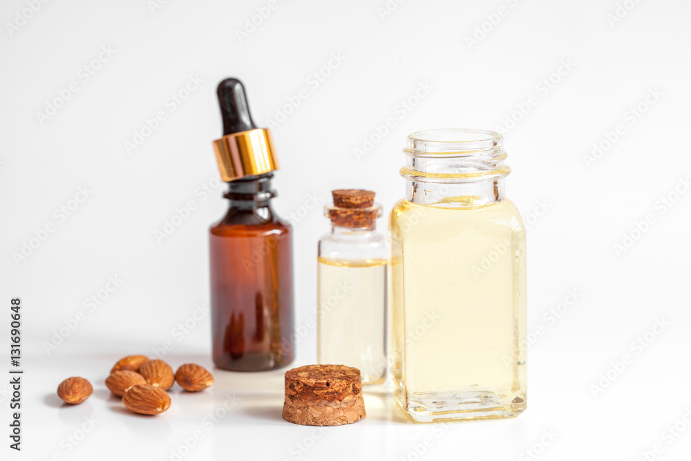 cosmetic almond oil in glass bottle on white background