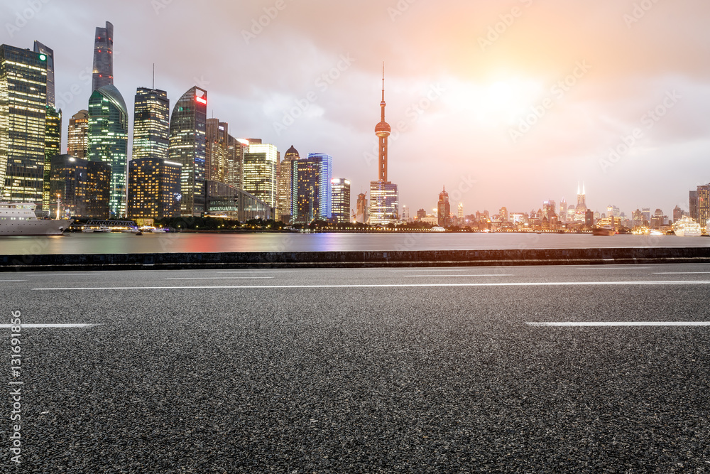 Asphalt road and modern cityscape at sunset in Shanghai