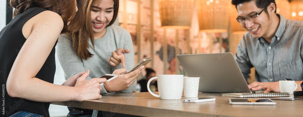 Group of friends meeting in a coffee shop chatting to each other