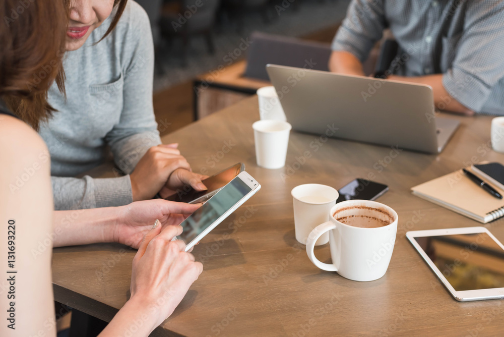 Group of friends meeting in a coffee shop chatting to each other