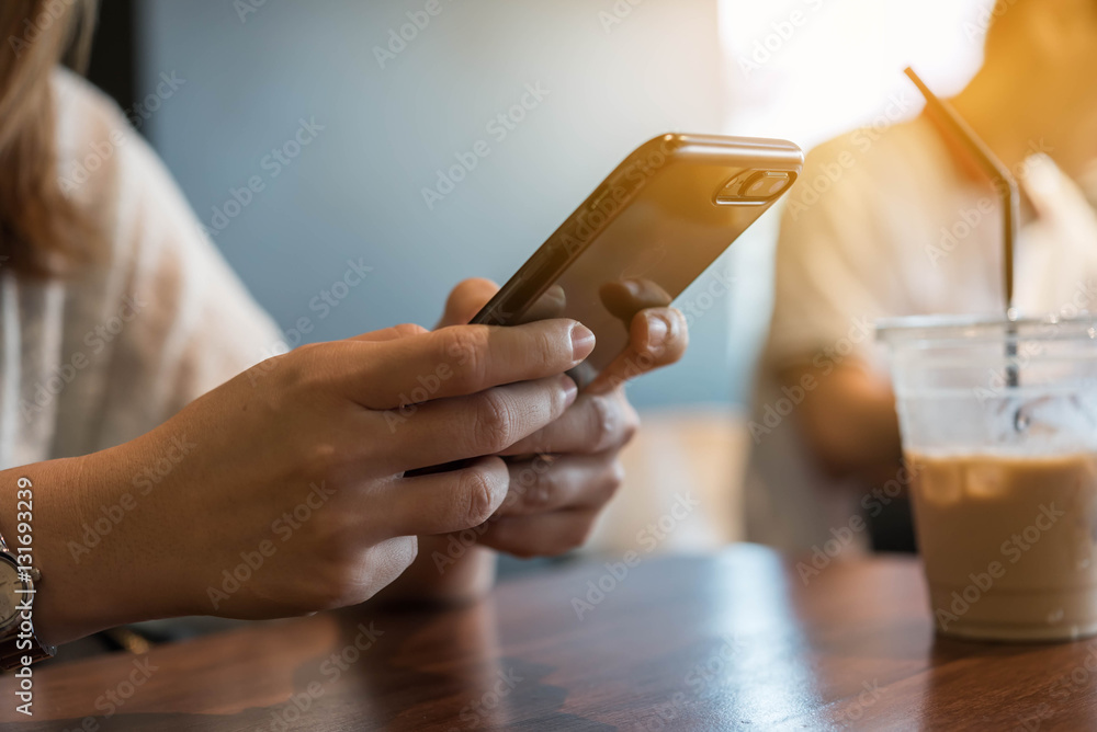 Close up of hand using smartphone in coffee shop