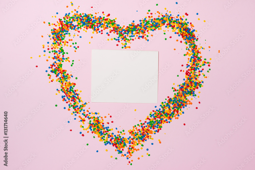 Valentines Day background. Heart shape with candies on pink.