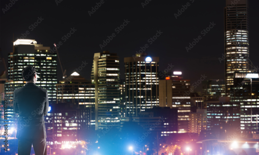 Businessman viewing night glowing city