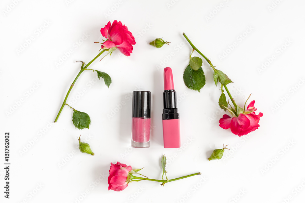 berry color decorative cosmetics with roses white background top view