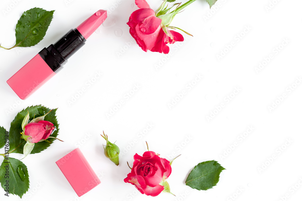 berry color decorative cosmetics with roses white background top view