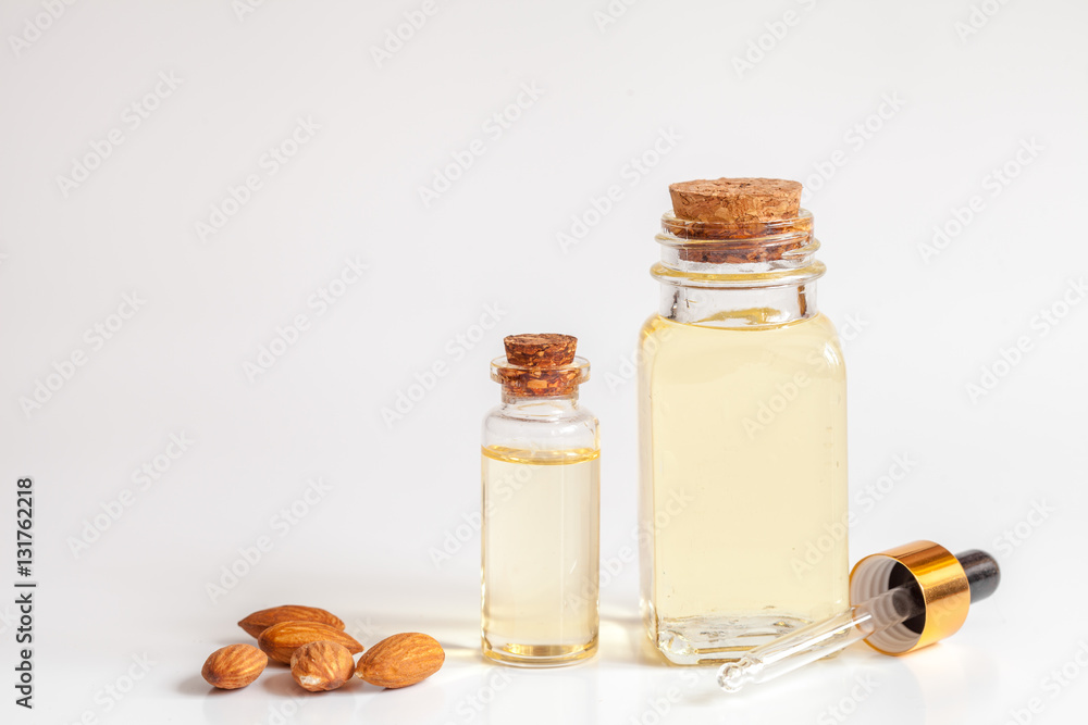 cosmetic almond oil in glass bottle on white background