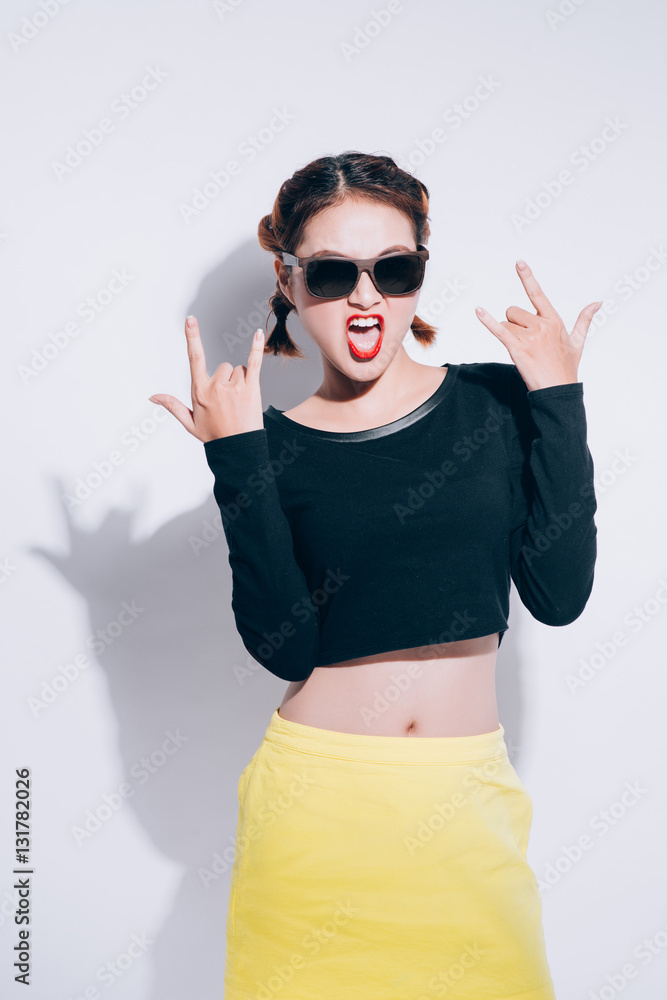 Young asian girl doing emotion. Dressed in a black shirt and yellow skirt, glasses and bright lips,t