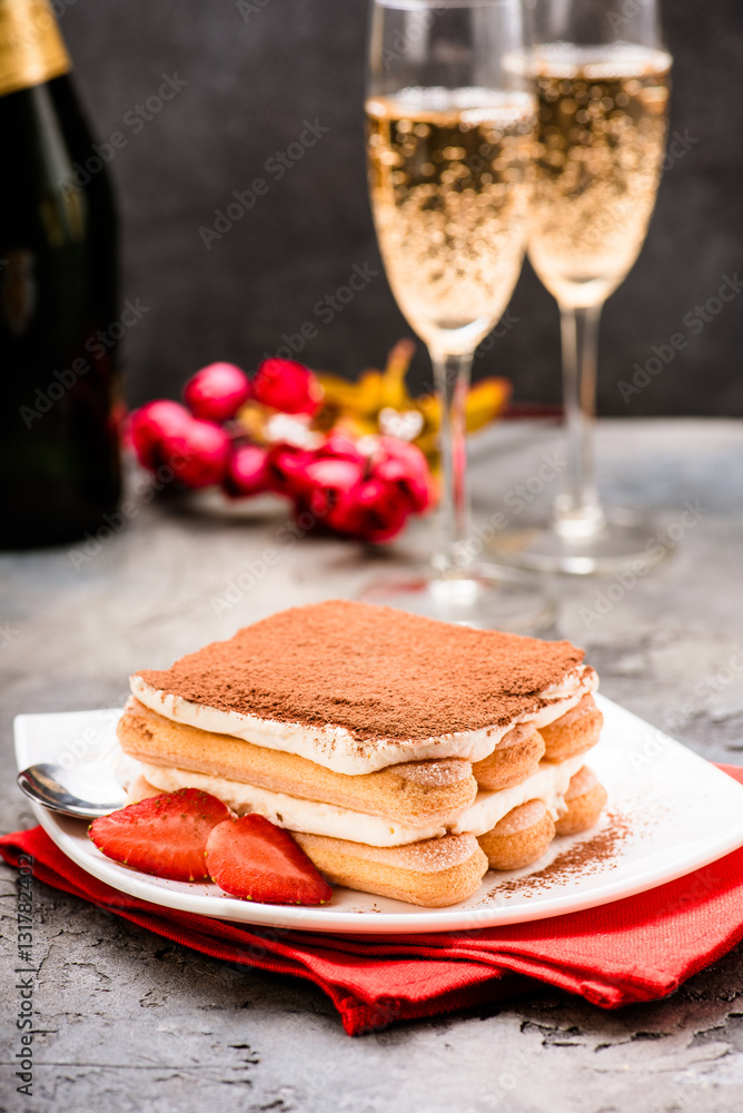 Tiramisu with strawberry and glasses of champagne on the table. Valentines concept.