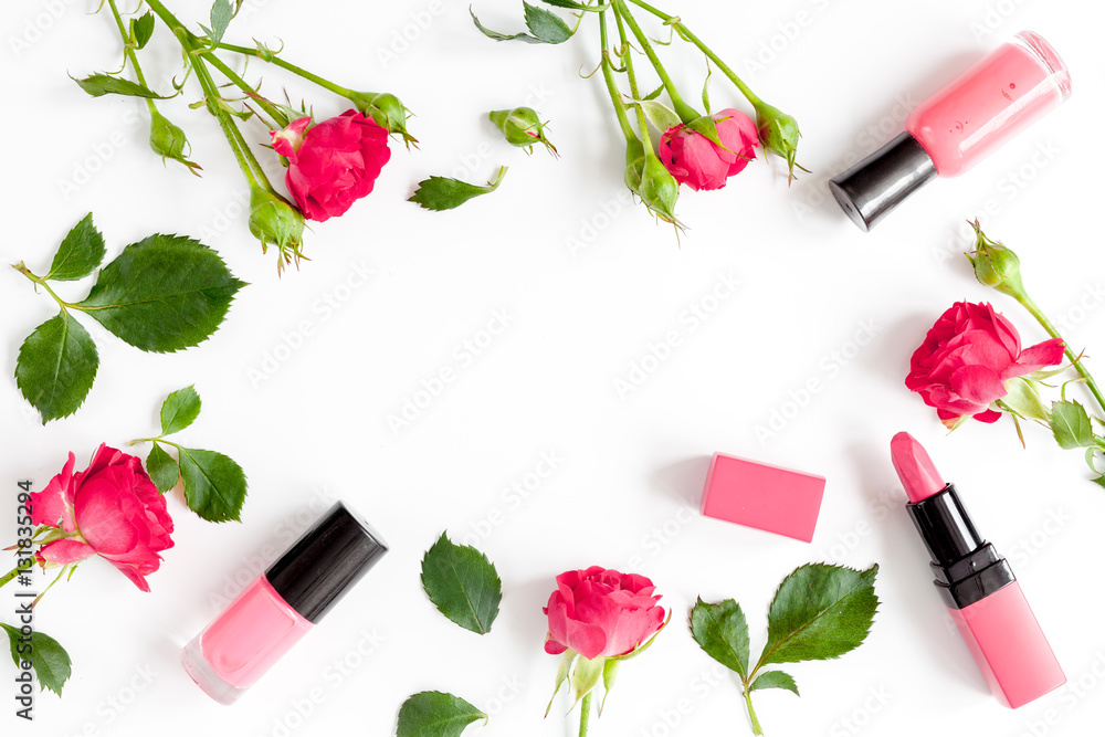 berry color decorative cosmetics with roses white background top view