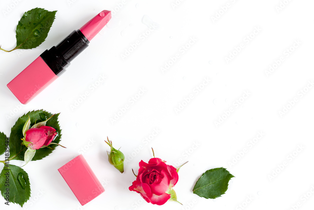 berry color decorative cosmetics with roses white background top view