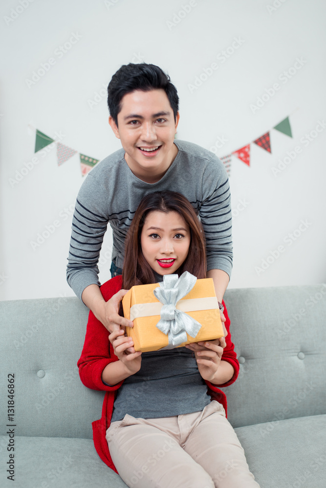 Christmas Asian Couple. A handsome man giving her girlfriend/wif