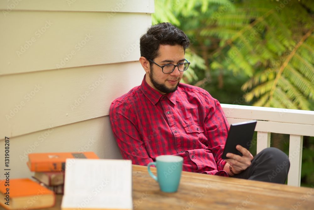 Young man with reader sitting outdoor