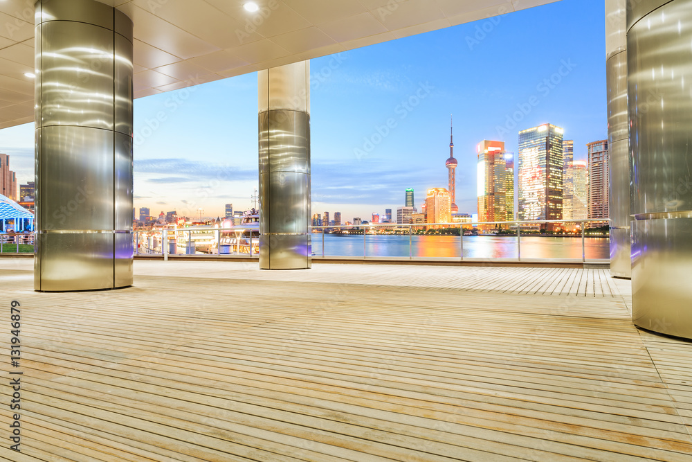 Empty floor with modern skyline and buildings at night in Shanghai