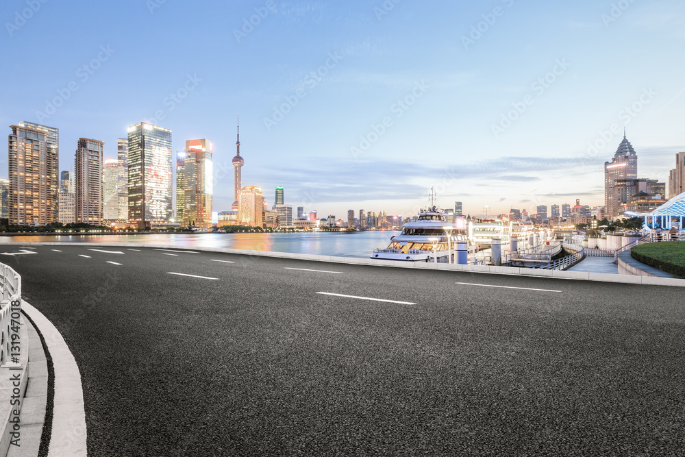 Asphalt road and modern cityscape at dusk in Shanghai