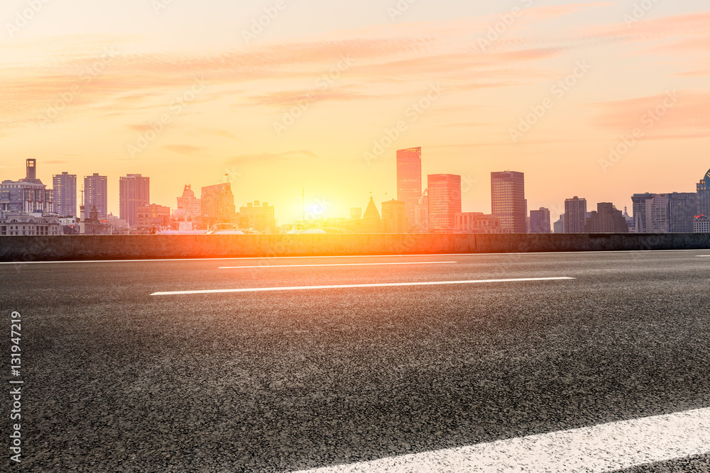 Asphalt road and modern cityscape at sunset in Shanghai