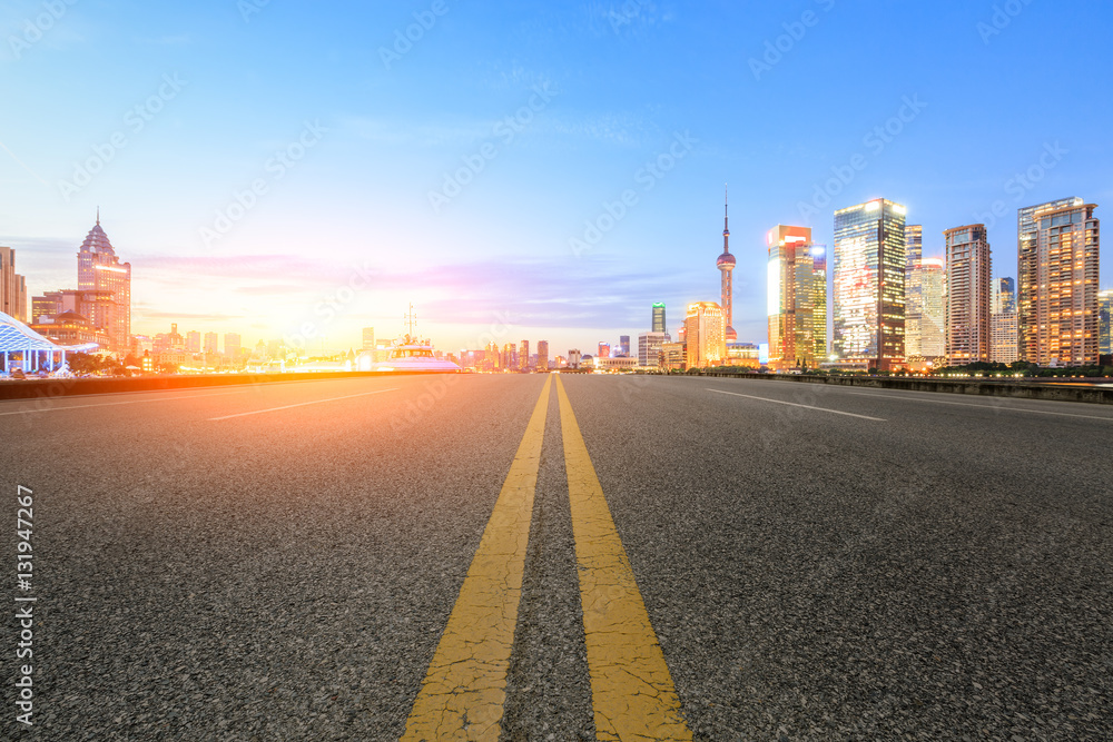 Asphalt road and modern cityscape at sunset in Shanghai