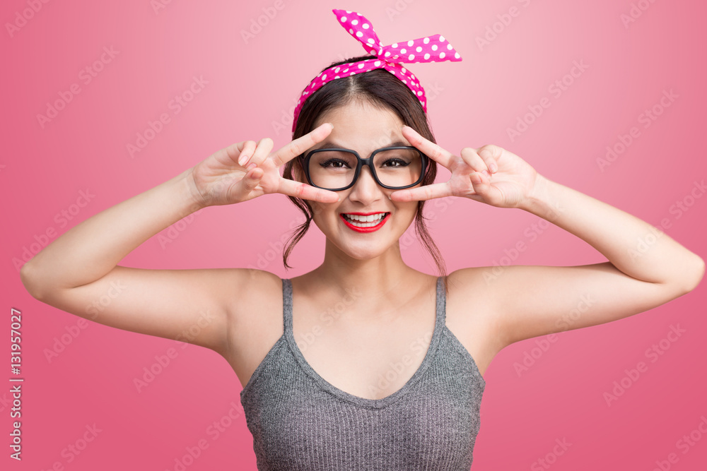 Fashion portrait of asian girl with sunglasses standing on pink