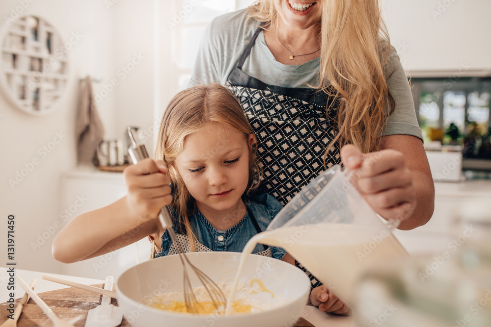 Mother and daughter mixing batter in bowl