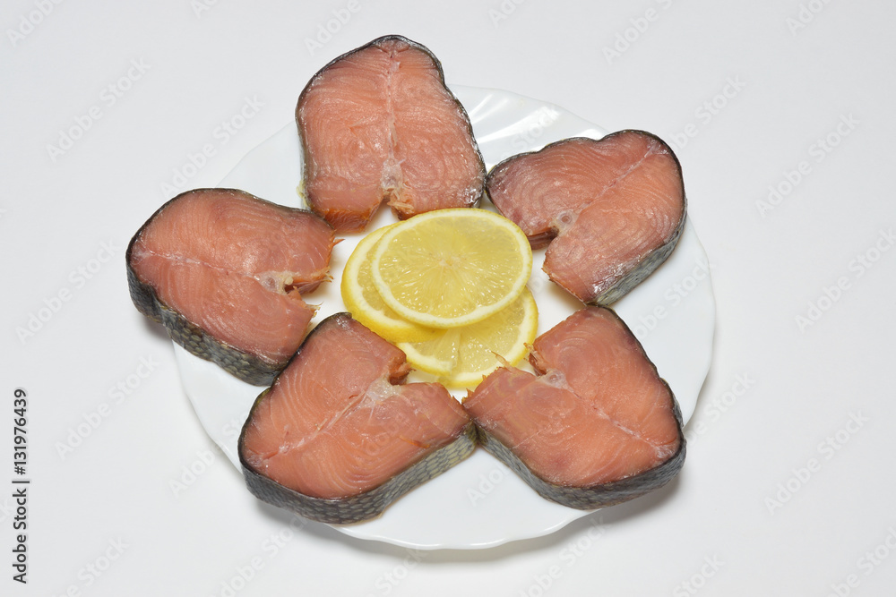 Amur Smoked salmon with lemon on a plate.