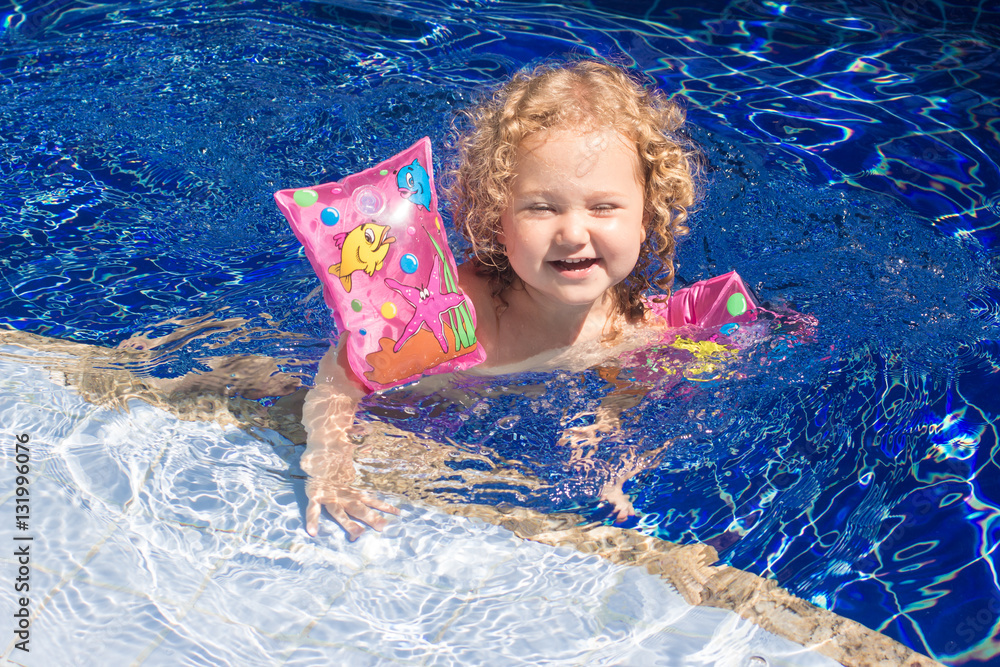 Child girl playing in the pool