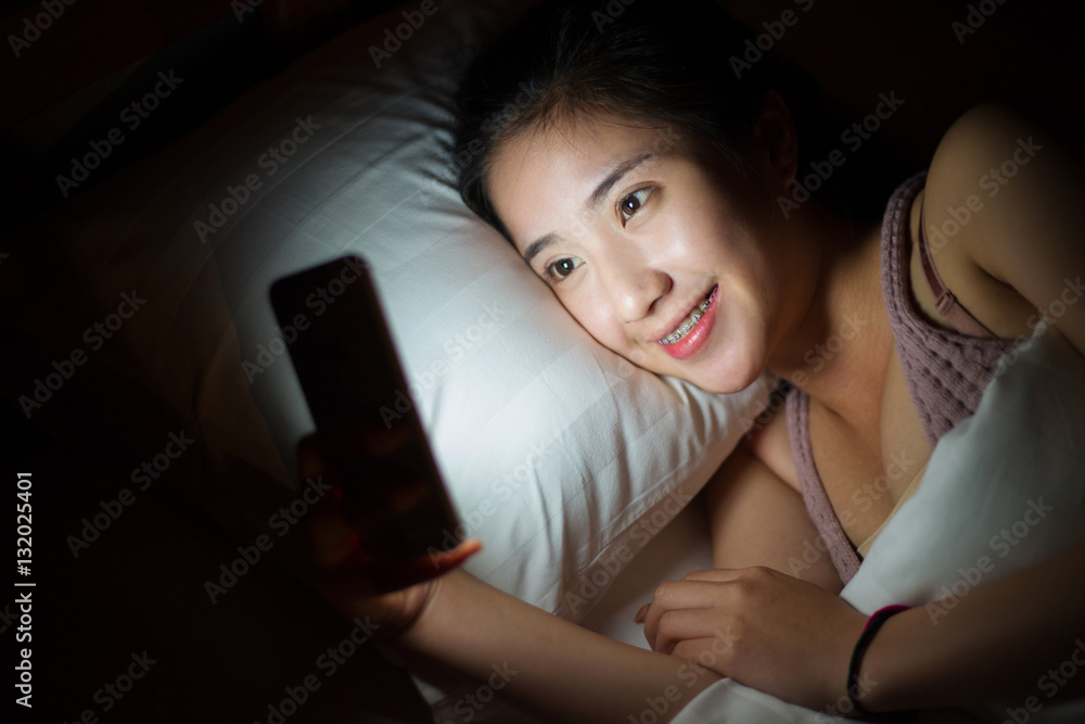 Woman use of mobile phone and lying on bed and turned off the li