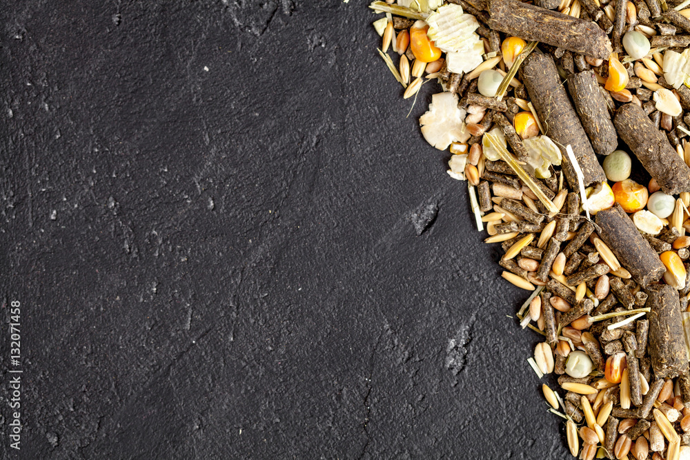 dry food for rodents on dark background top view