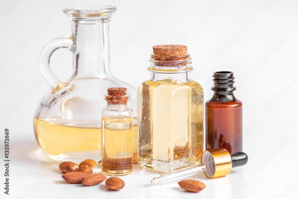 cosmetic almond oil in glass bottle on white background