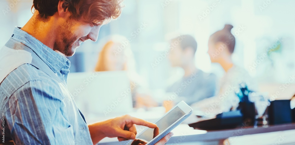 Smiling young man using digital tablet