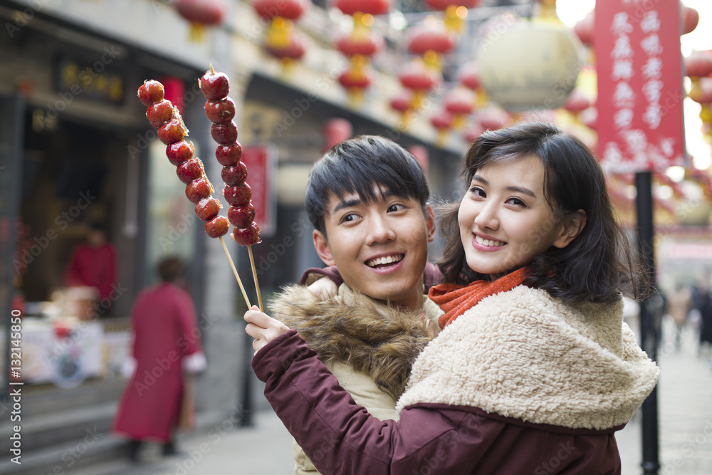 Young couple with candied haw berries celebrating Chinese New Year