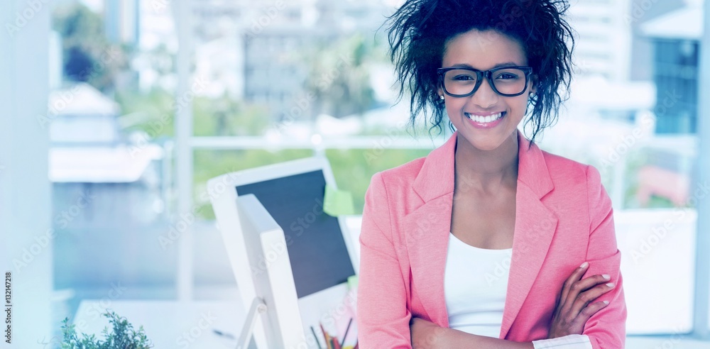 Casual female artist with arms crossed at bright office