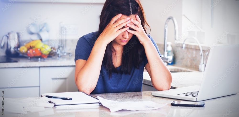 Stressed woman looking down at bills