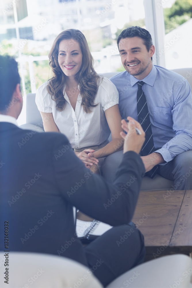 Smiling couple in meeting with a financial adviser