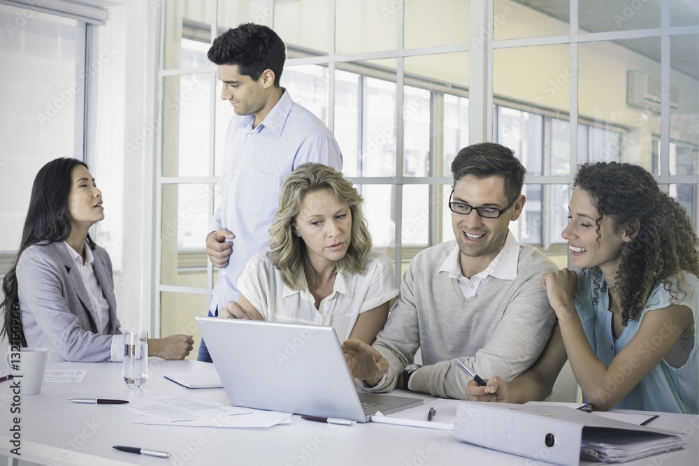 Casual business team having a meeting using laptop