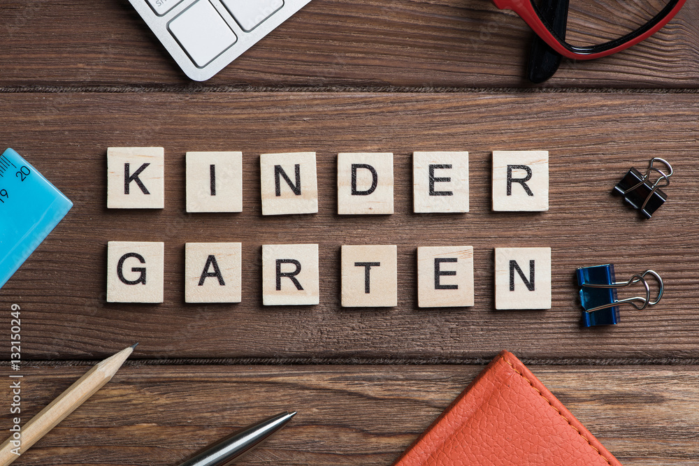 Office stuff and Kinder Garden phrase collected with letters on table