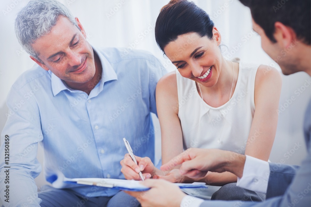 Smiling woman sign on a contrat with her partnership on sofa 