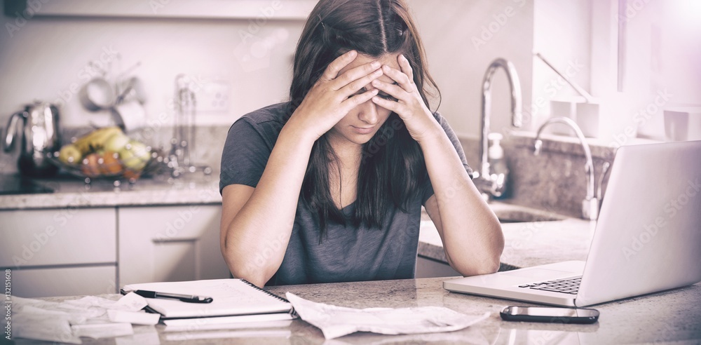 Stressed woman looking down at bills