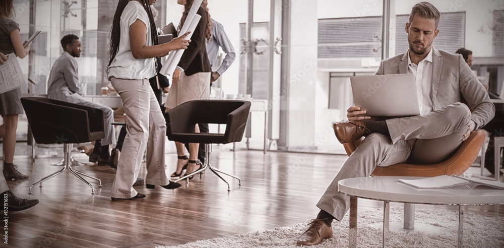 Businessman with colleagues using laptop