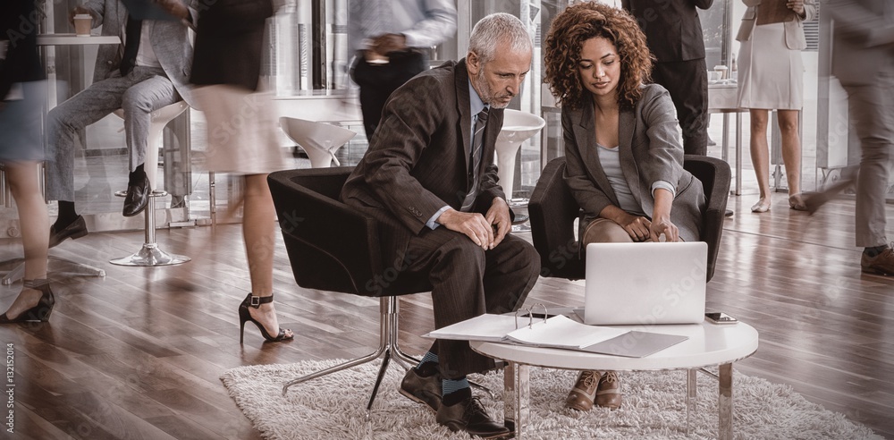 Business people looking into laptop