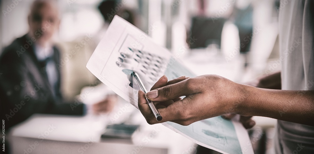 Businesswoman showing chart in office