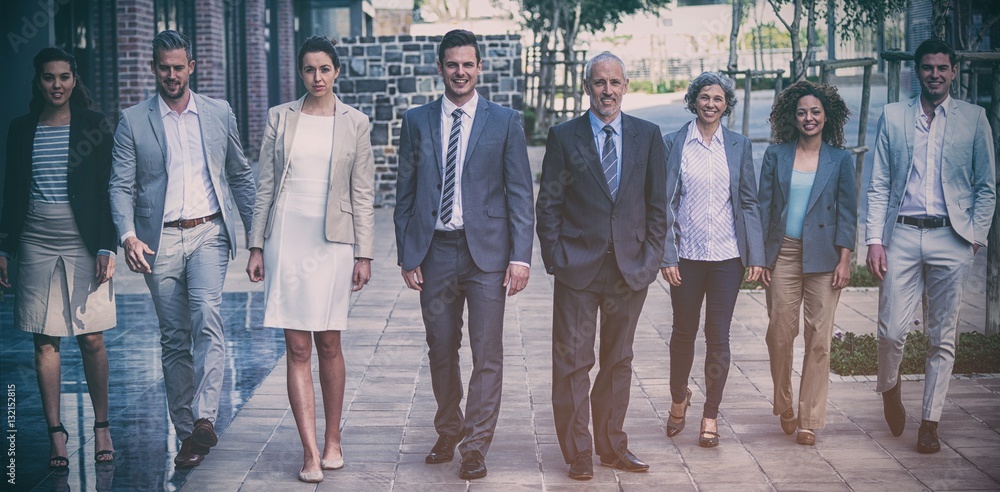 Smiling business people walking outside office