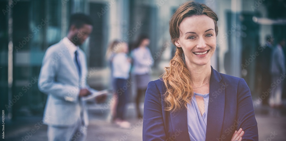 Smiling businesswoman standing with arms crossed