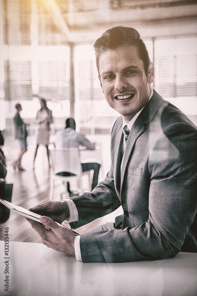 Smiling businessman using digital tablet office