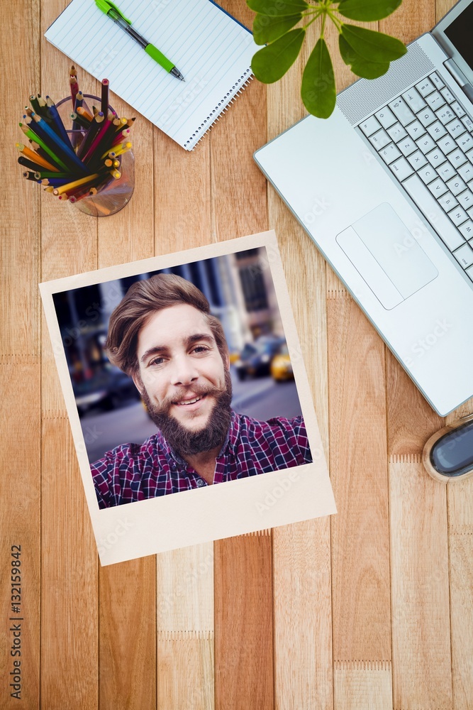 Composite image of happy hipster against wooden fence