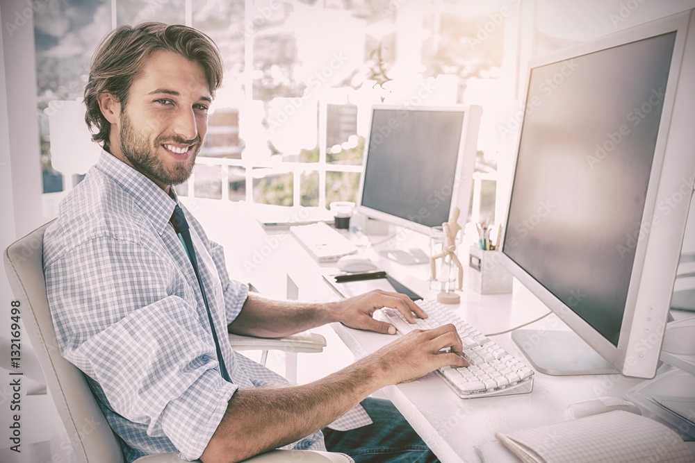 Smiling designer working at his desk