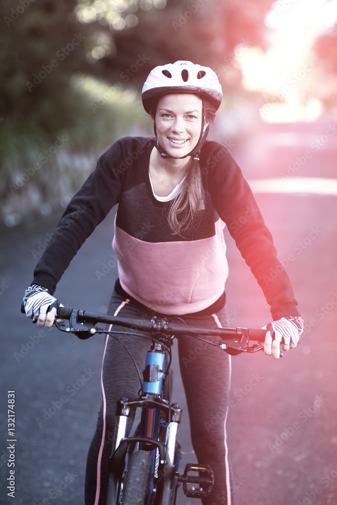 Portriat of female biker with mountain bike in countryside