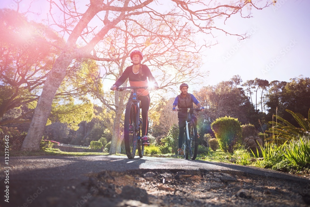 Low angle view of biker couple cycling on countryside road