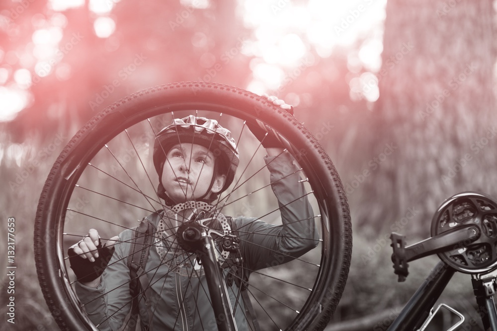 Female biker repairing mountain bike