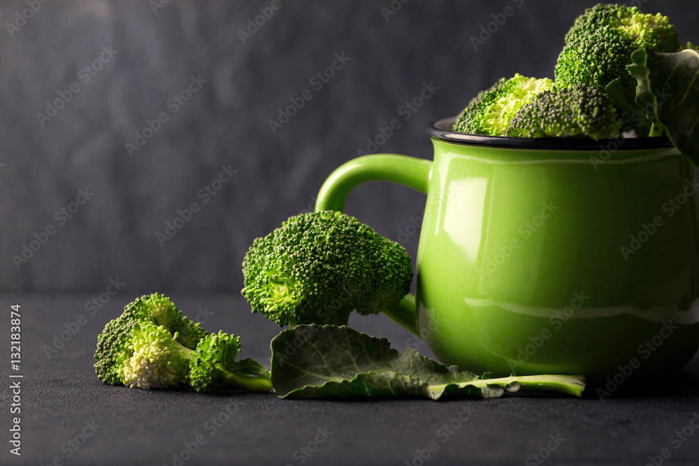 still life with fresh green broccoli in ceramic cup